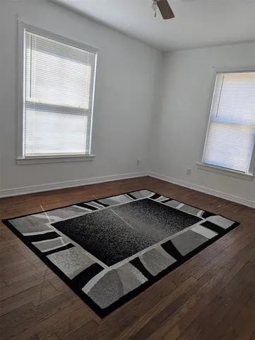 a view of a room with wooden floor and window
