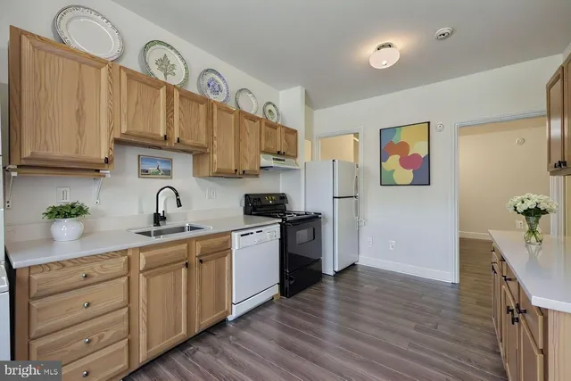 a kitchen with stainless steel appliances granite countertop a sink a stove a refrigerator and cabinets