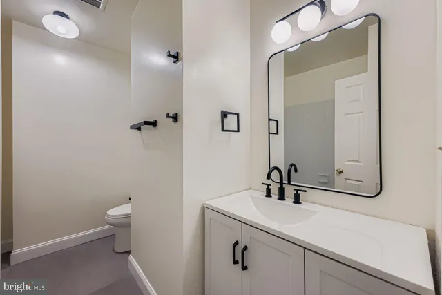 a bathroom with a sink a toilet and mirror