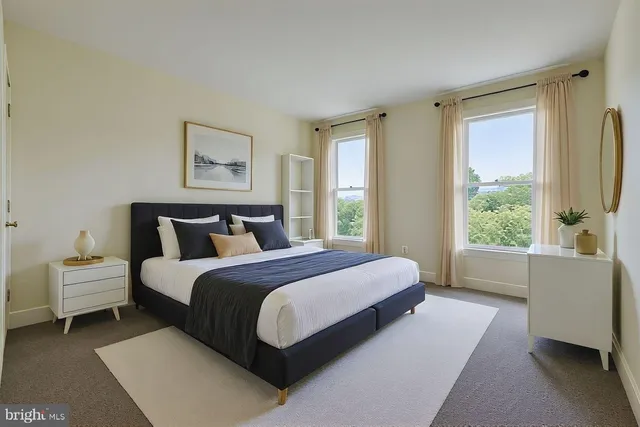 a spacious bedroom with a bed and a large window