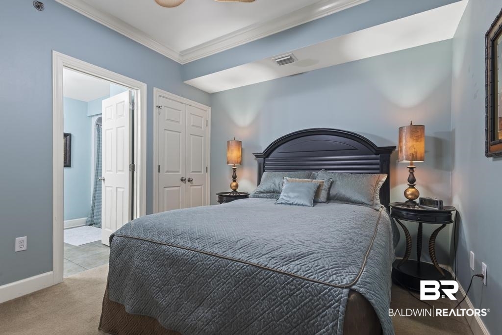 27582 Canal Road, Unit 2408 Orange Beach, AL 36561 - Photo 16 of 47 Bedroom with ceiling fan, crown molding, light colored carpet, and a closet