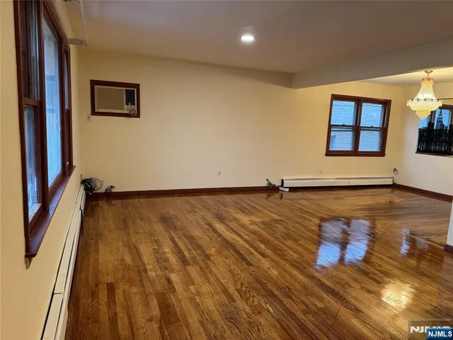 a view of a room with wooden floor and window