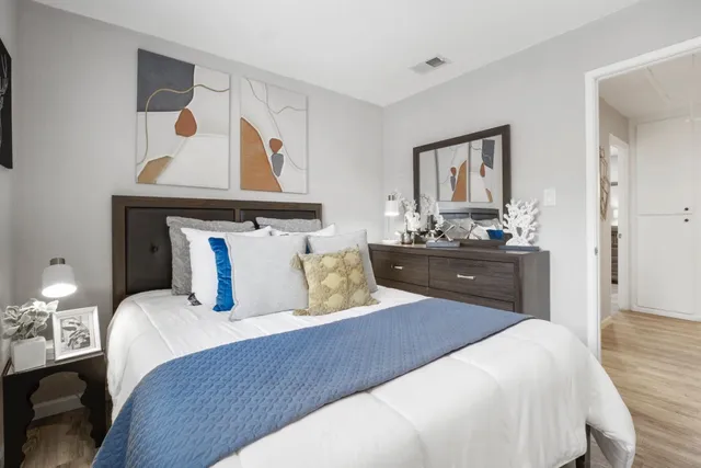 a bedroom with a bed and wooden floor