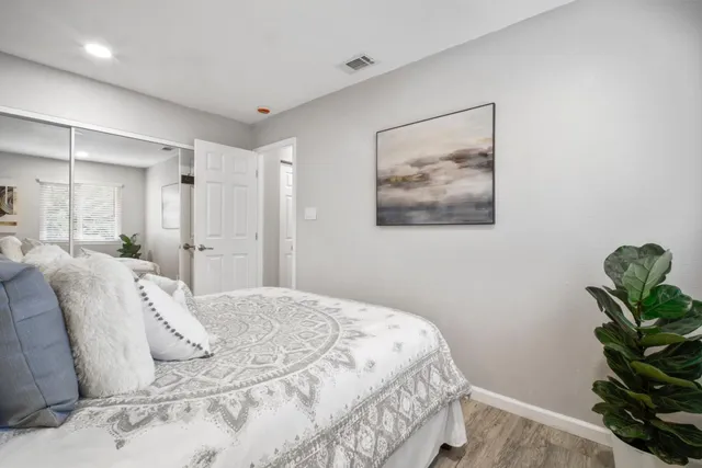 a bedroom with a bed and a painting on the wall