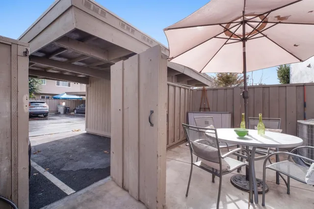 a view of a patio with a table and chairs under an umbrella