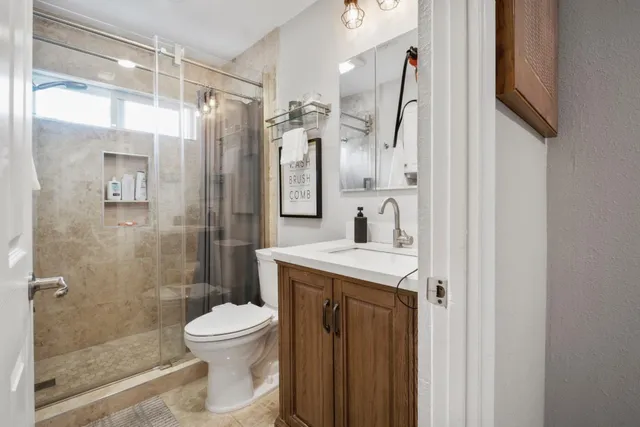 a bathroom with a sink a toilet and shower