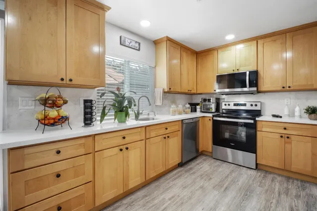 a kitchen with sink cabinets and stainless steel appliances