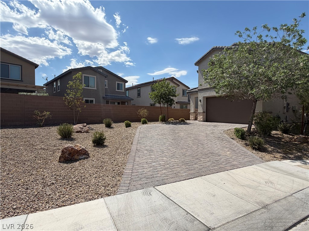 3228 Azalea Ridge Court Henderson, NV 89052 - Photo 2 of 28 A neatly paved driveway leads to a welcoming residence, framed by desert-friendly landscaping.