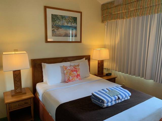 3411 Wilcox Road, Unit 110 Lihue, HI 96766 - Photo 9 of 12 a bedroom with a bed and wooden floor