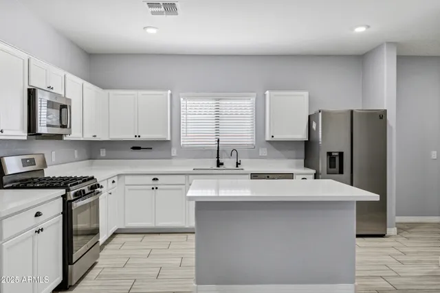a kitchen with a sink a stove a refrigerator and cabinets