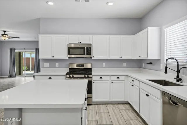 a kitchen with a sink a stove and cabinets