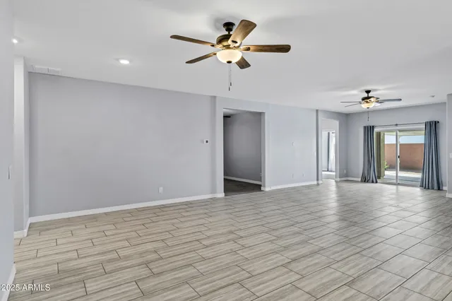 a view of an empty room with a ceiling fan