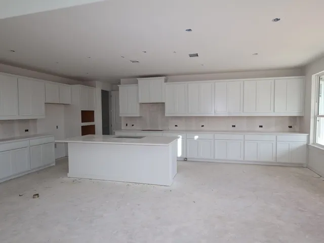 a large white kitchen with white cabinets and white appliances