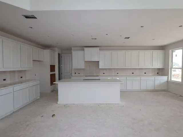 a large white kitchen with white cabinets
