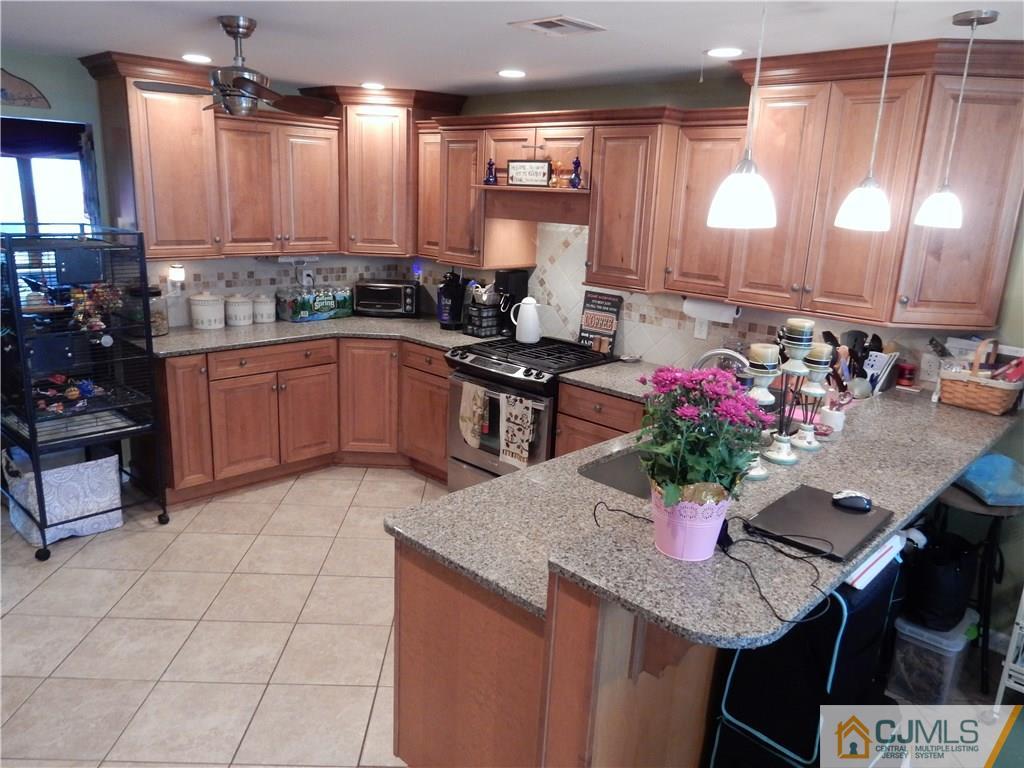 61 Kimberly Road Colonia, NJ 07067 - Photo 5 of 25 a kitchen with stainless steel appliances granite countertop a sink refrigerator and cabinets