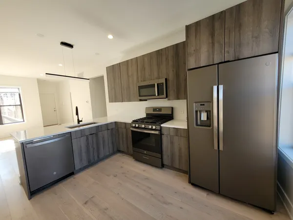 a kitchen with stainless steel appliances granite countertop a refrigerator and a stove top oven