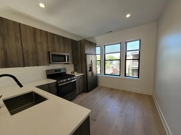 a kitchen with a refrigerator and a stove top oven