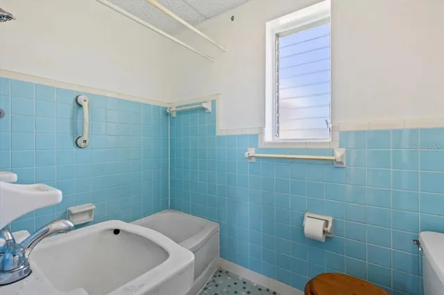 a bathroom with a sink a toilet and a mirror