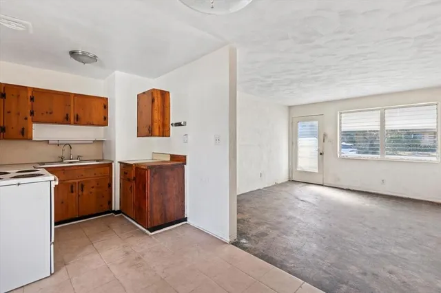 an empty room with kitchen and window