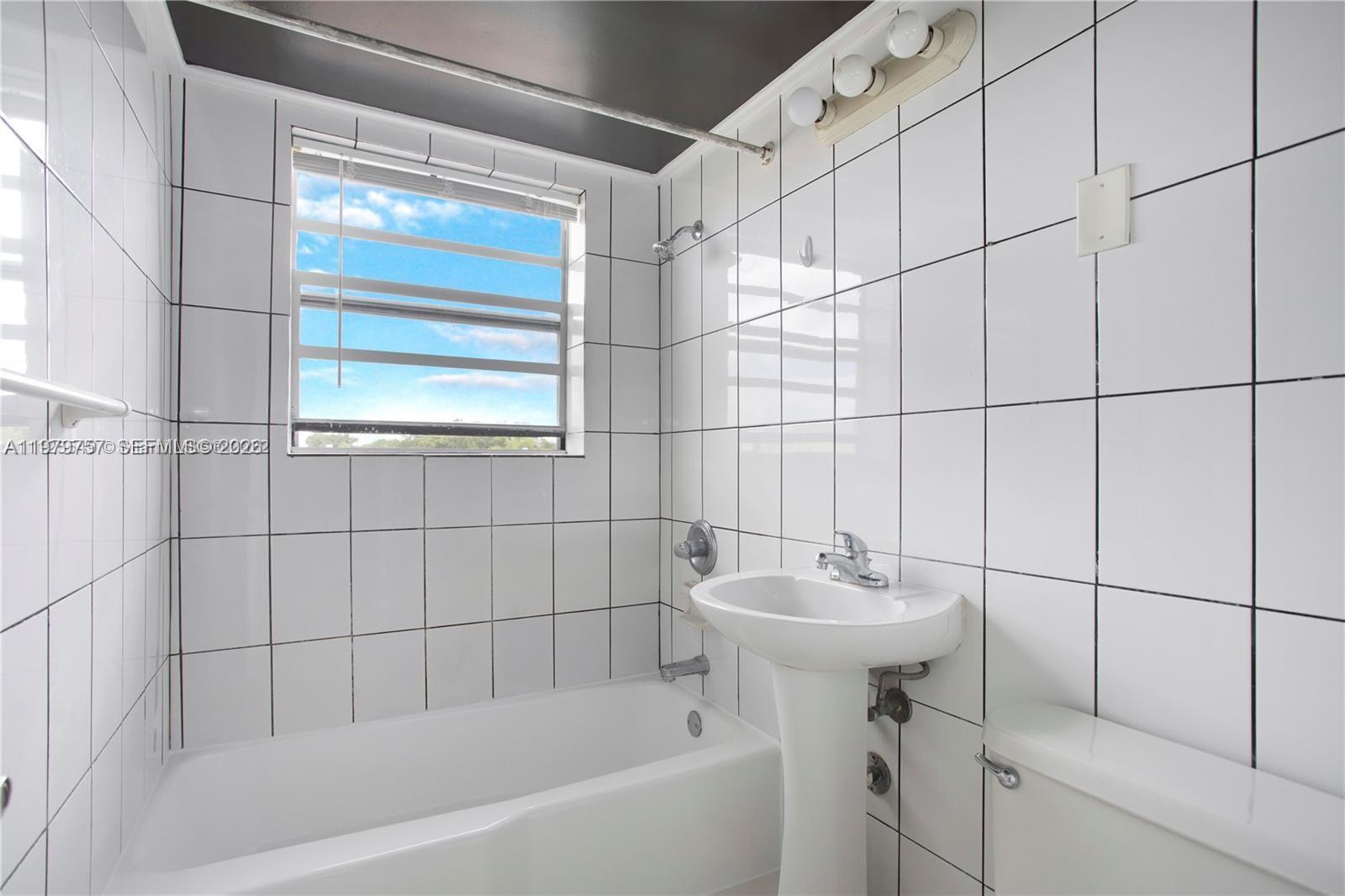 1020 Southwest 7th Street, Unit 9 Miami, FL 33130 - Photo 12 of 13 a white bath tub sitting next to a white sink