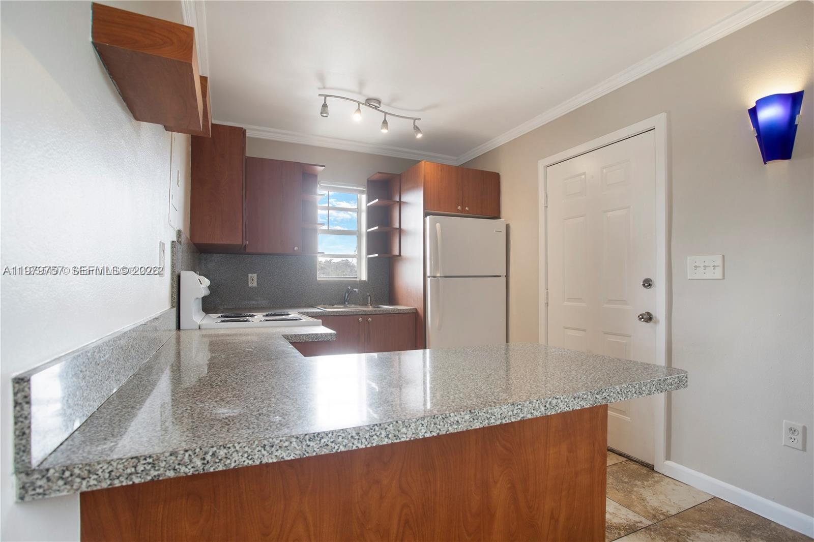 1020 Southwest 7th Street, Unit 9 Miami, FL 33130 - Photo 2 of 13 a kitchen with stainless steel appliances granite countertop a refrigerator a sink and a stove