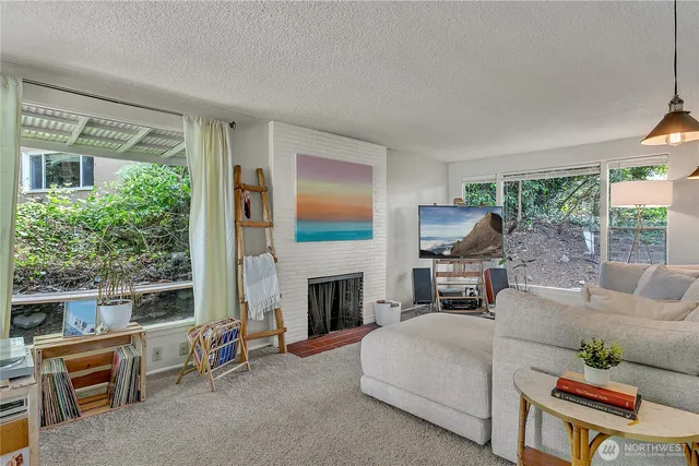 a living room with furniture a fireplace and a large window