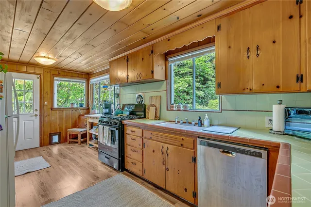 a kitchen that has a sink a window and stainless steel appliances