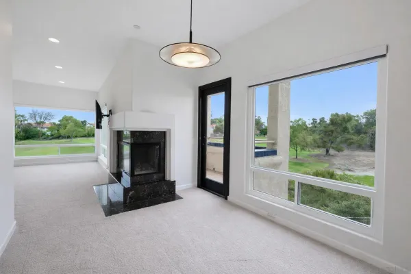 a view of an empty room with a fireplace and a window