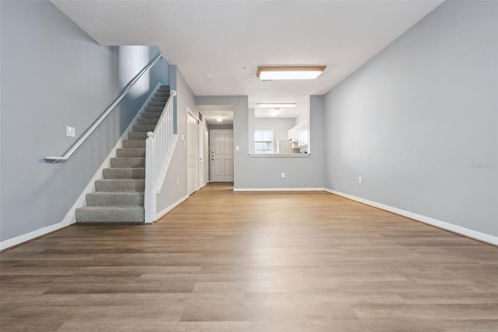 720 Celebration Avenue, Unit 220 Celebration, FL 34747 - Photo 14 of 45 a view of an empty room with wooden floor and stairs