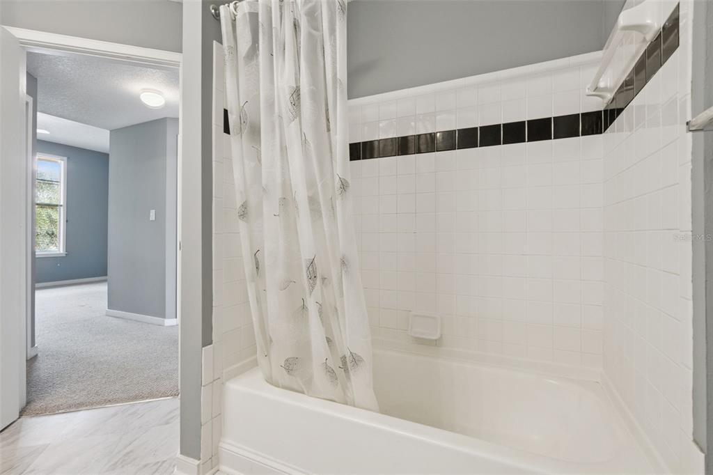 720 Celebration Avenue, Unit 220 Celebration, FL 34747 - Photo 19 of 45 a bathroom with a bathtub and a shower