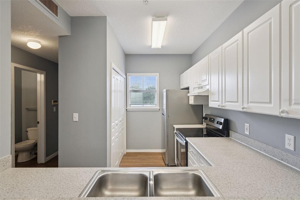 720 Celebration Avenue, Unit 220 Celebration, FL 34747 - Photo 7 of 45 a kitchen with stainless steel appliances granite countertop a sink refrigerator and cabinets