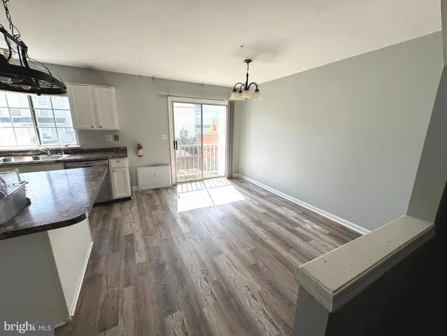 a view of a kitchen with wooden floor and electronic appliances