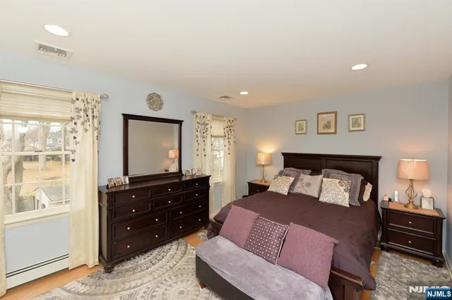 a bedroom with a bed and a dresser with mirror