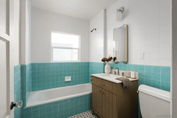 a bathroom with a sink a toilet a mirror and bathtub