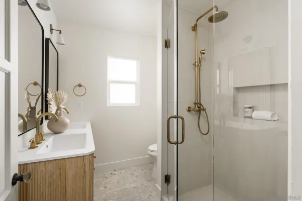 a bathroom with a sink a vanity mirror and shower