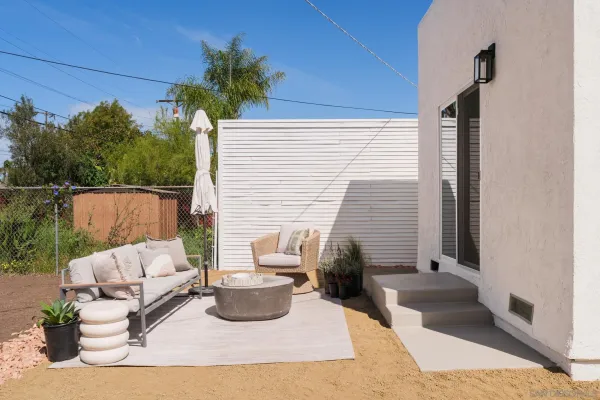 a view of a patio with couches table and chairs and potted plants