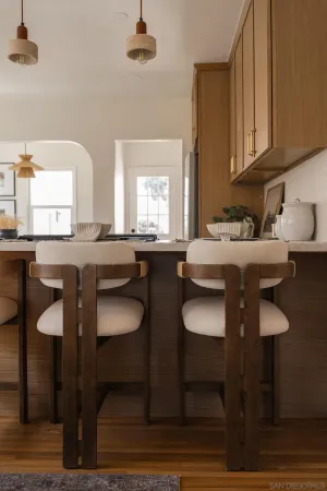a kitchen with granite countertop a table chairs stove and cabinets