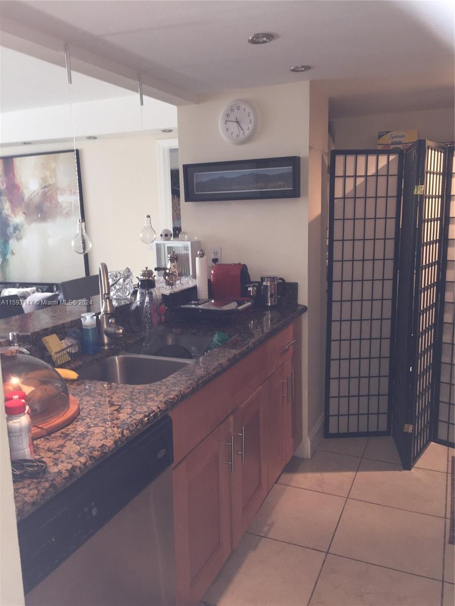 540 Brickell Key Drive, Unit 1511 Miami, FL 33131 - Photo 23 of 24 a bathroom with a granite countertop sink a mirror and vanity