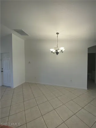 an empty room with chandelier fan
