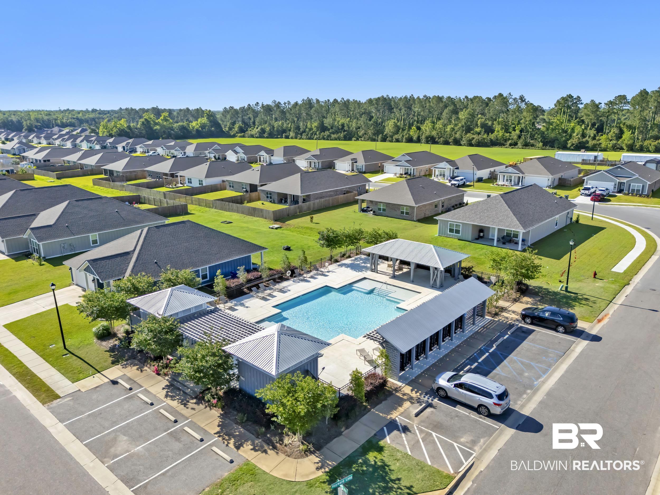1228 Caper Avenue Foley, AL 36535 - Photo 39 of 54 Community swimming pool featuring a tanning ledge and surrounding lounge areas