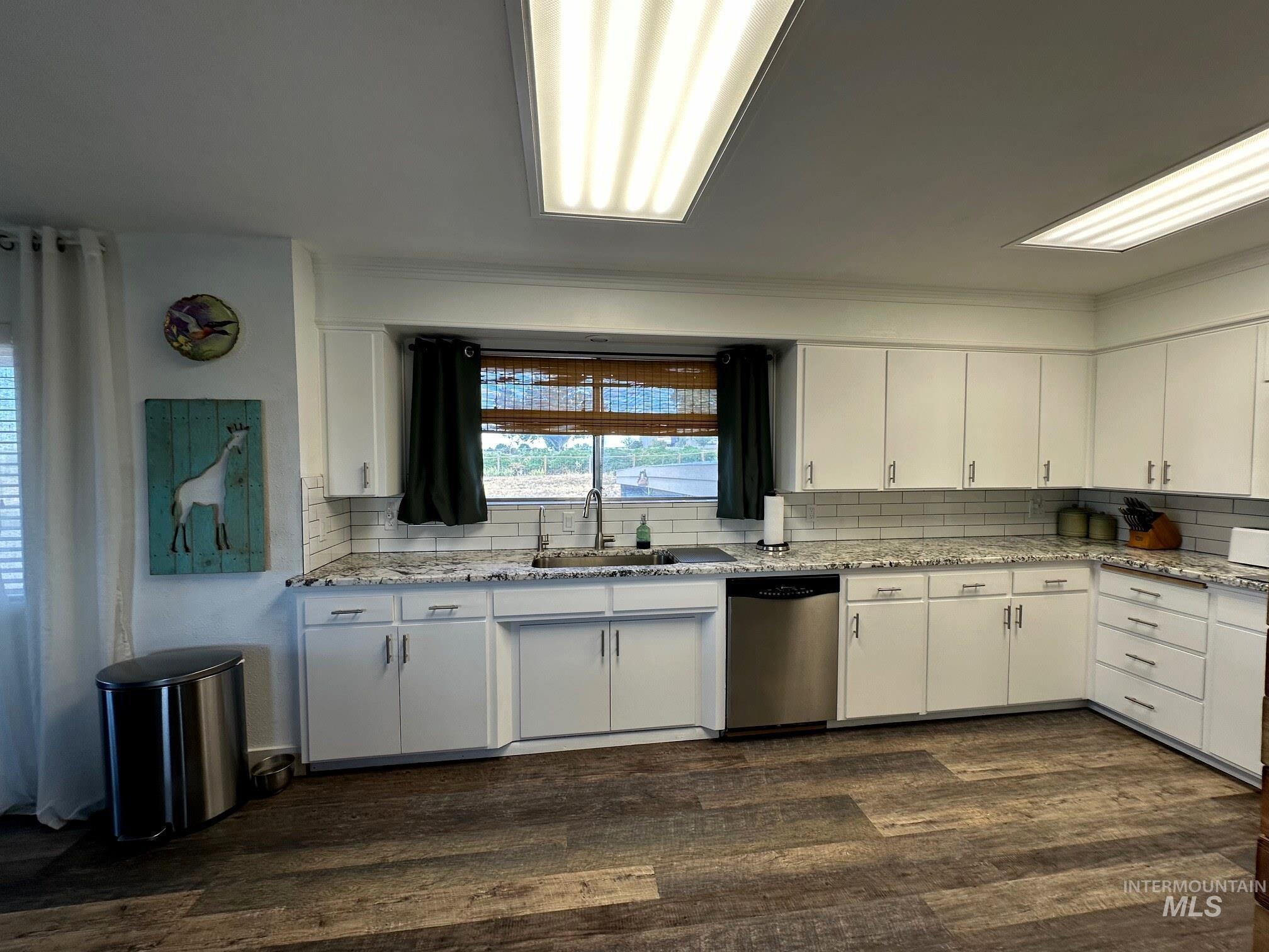 4436 Baker Road Ontario, OR 97914 - Photo 3 of 30 Kitchen featuring white cabinetry, light stone counters, decorative backsplash, stainless steel dishwasher, and dark wood-style flooring