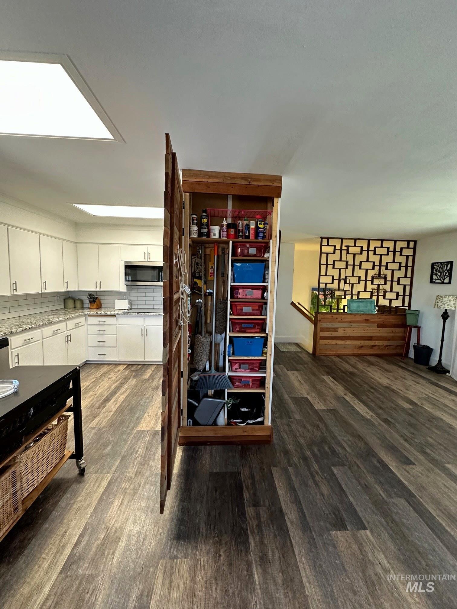 4436 Baker Road Ontario, OR 97914 - Photo 6 of 30 Detailed view of dark wood-type flooring, stainless steel microwave, and white cabinetry
