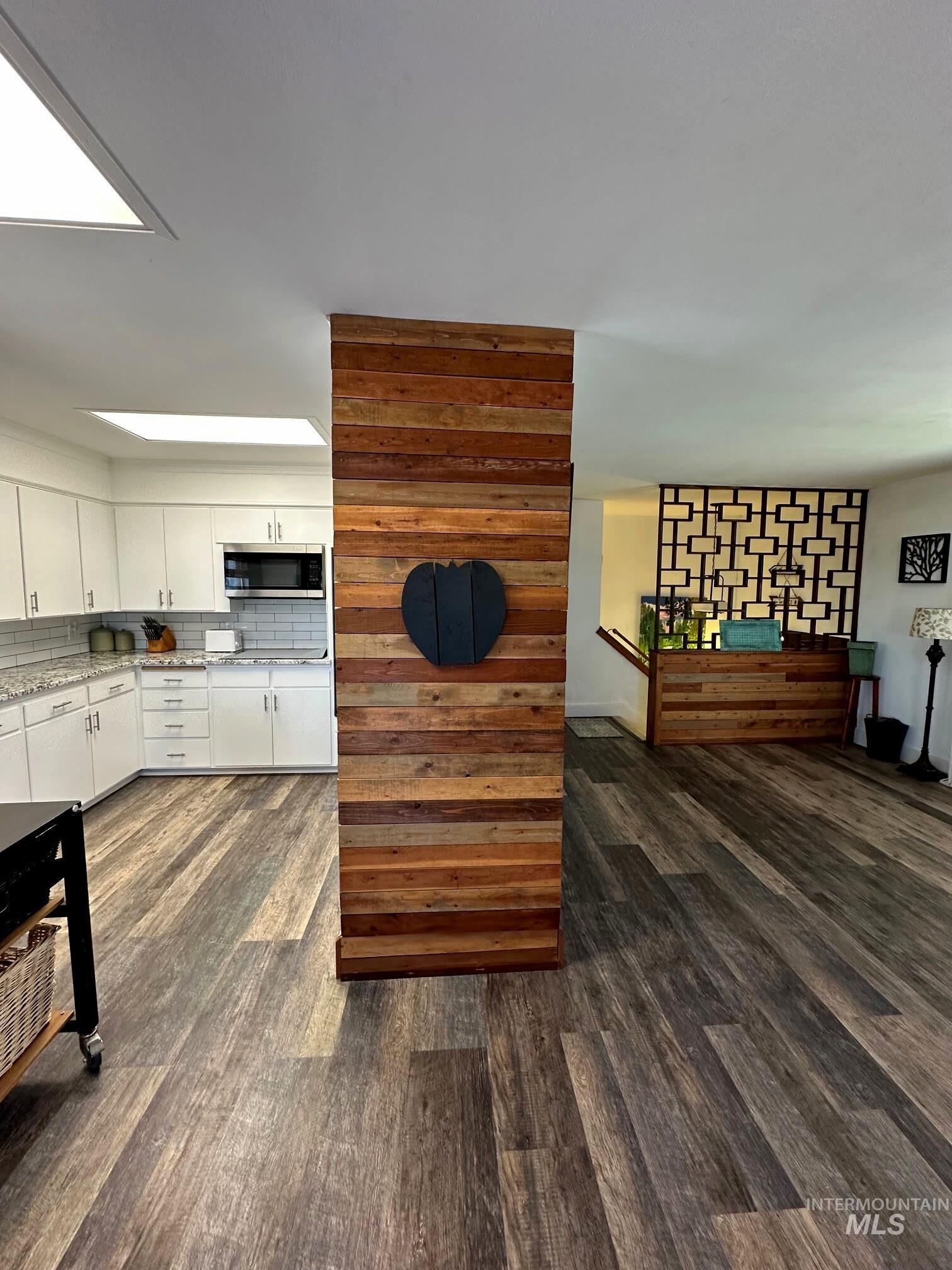 4436 Baker Road Ontario, OR 97914 - Photo 7 of 30 Kitchen with dark wood-style floors, stainless steel microwave, white cabinets, and light stone countertops