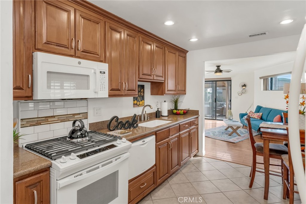 5142 West 142nd Street Hawthorne, CA 90250 - Photo 12 of 56 a kitchen with stainless steel appliances granite countertop a stove a sink dishwasher and cabinets with wooden floor