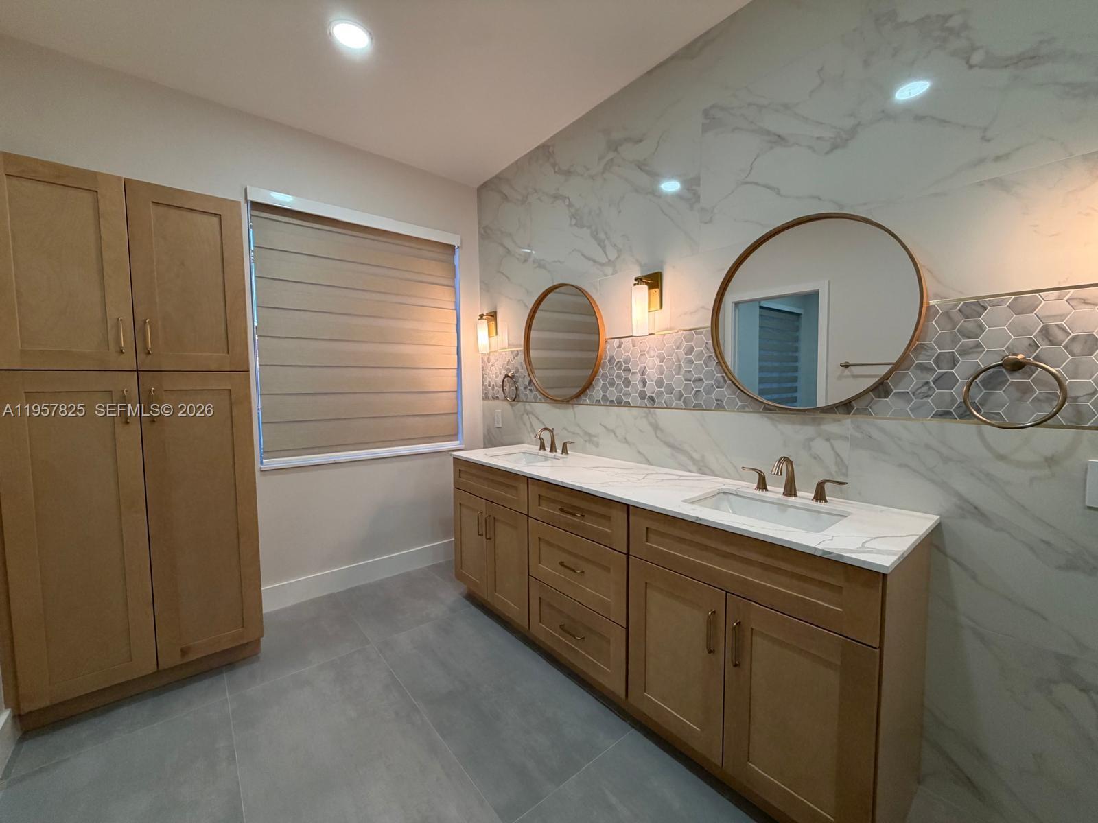 755 Falling Water Road Weston, FL 33326 - Photo 32 of 52 a bathroom with a double vanity sink and a mirror