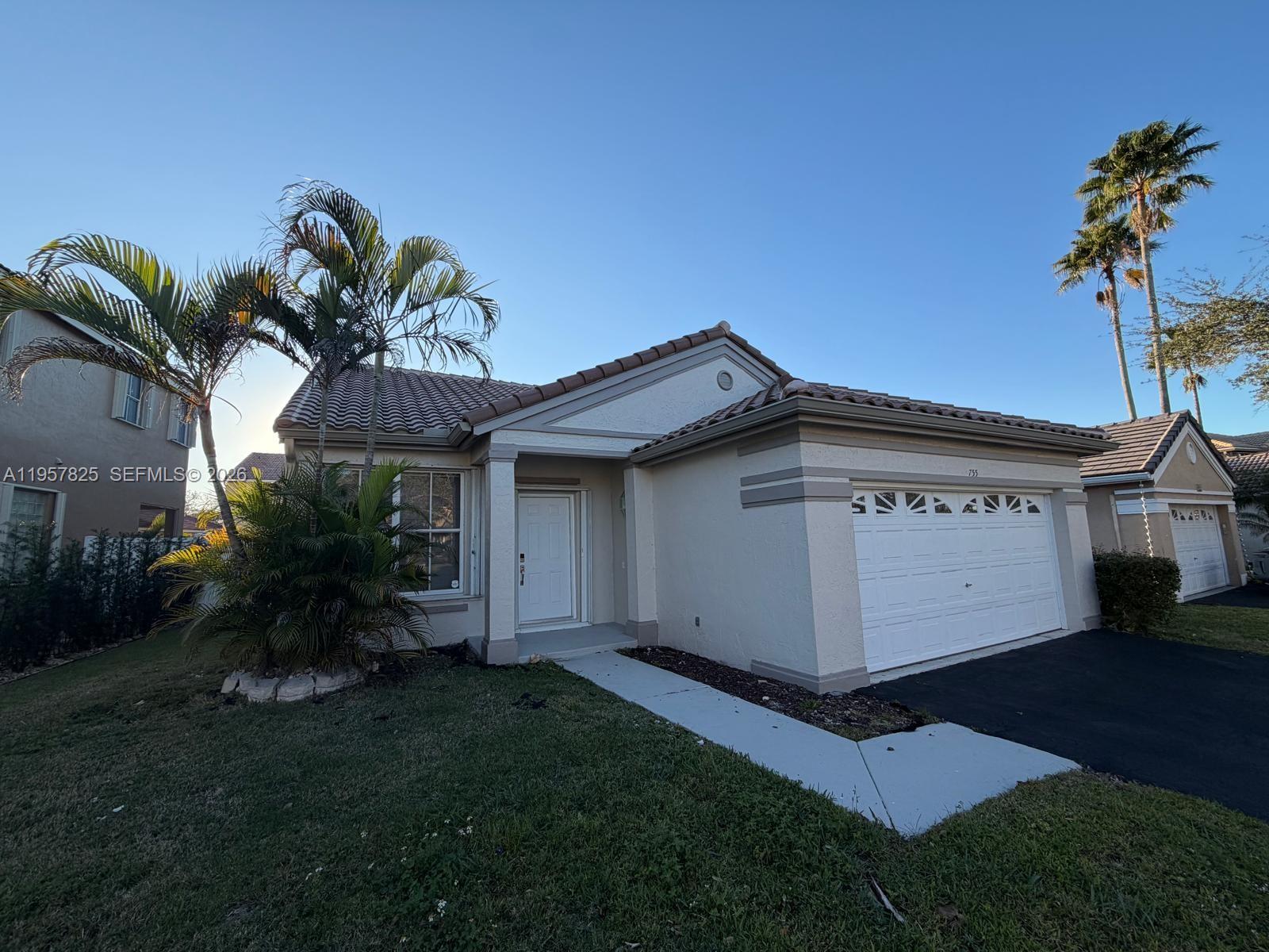 755 Falling Water Road Weston, FL 33326 - Photo 44 of 52 a white house with a small yard and potted plants