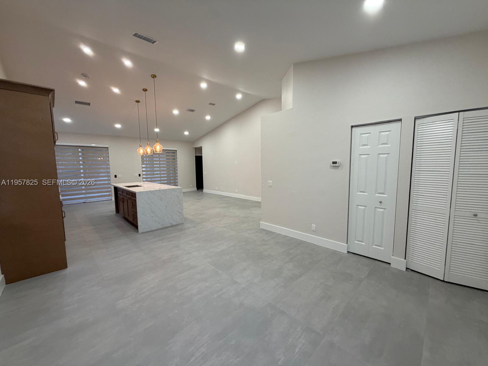755 Falling Water Road Weston, FL 33326 - Photo 6 of 52 an empty room with kitchen and windows