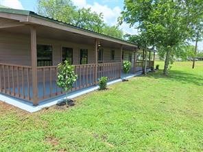 a view of a house with a yard and wooden fence