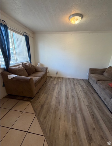 72 300 North, Unit 302 Provo, UT 84601 - Photo 5 of 16 Spacious interior featuring wood-finish flooring, a neutral wall palette, crown molding, and an overhead flush-mount light fixture