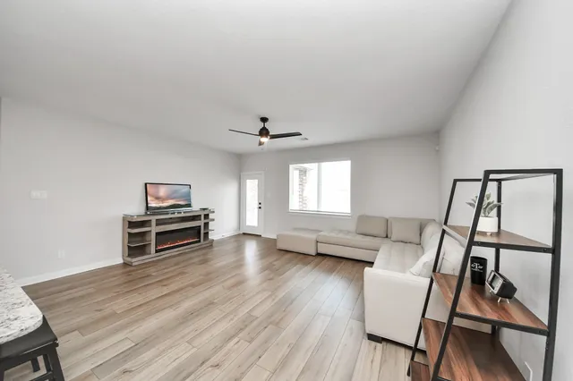a living room with furniture and a wooden floor